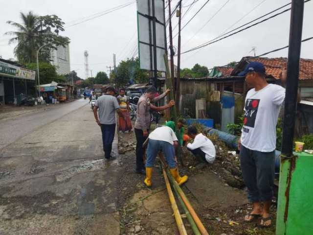 Bhabinkamtibmas Polsek Babakan Madang Gotong Royong Bersama Warga Desa Kadumanggu.